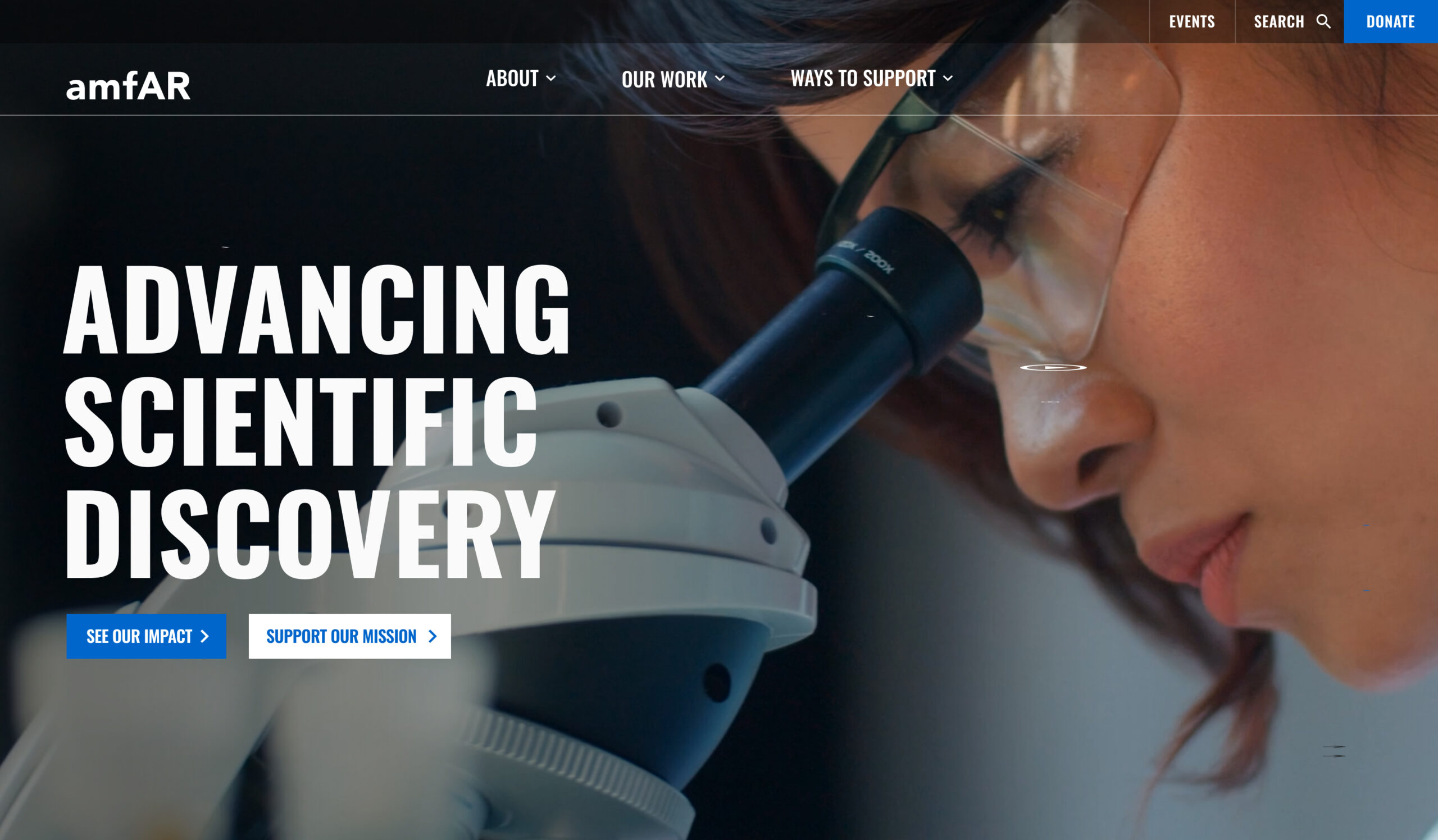 Person looking into a microscope with website navigation and the text “ADVANCING SCIENTIFIC DISCOVERY” and “SUPPORT OUR MISSION”